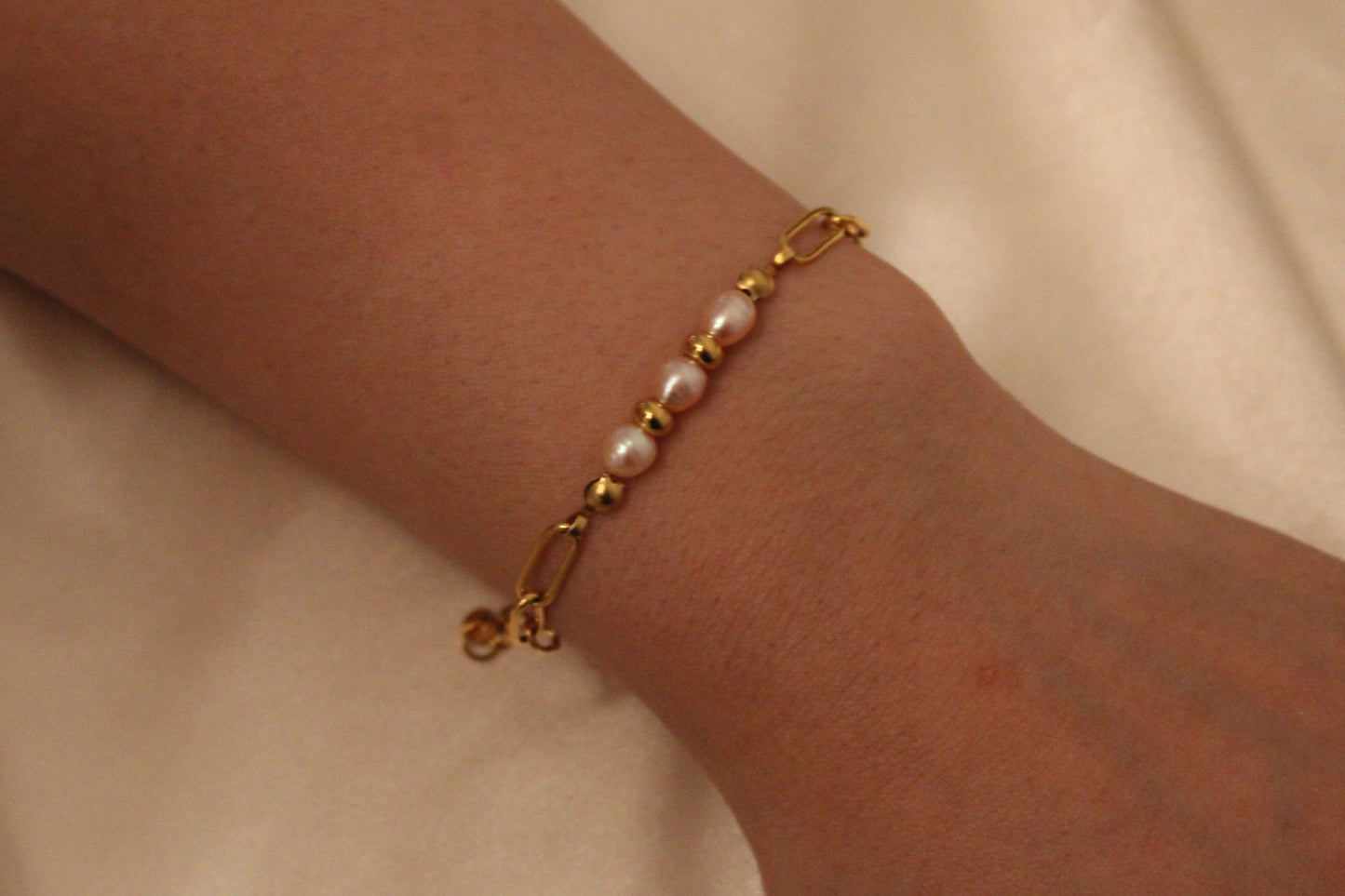 Elegante armband met roze parels aan een vrouwenpols – uniek handgemaakt ontwerp