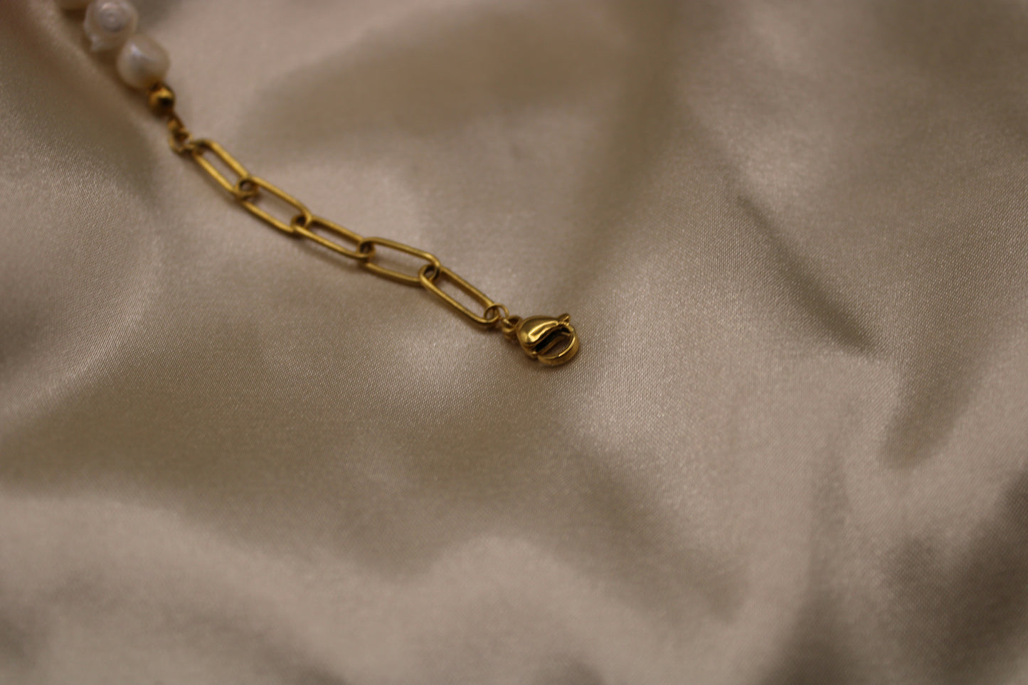 Stijlvolle armband met parels en carneool edelsteen, afgewerkt in goudkleurig stainless steel.