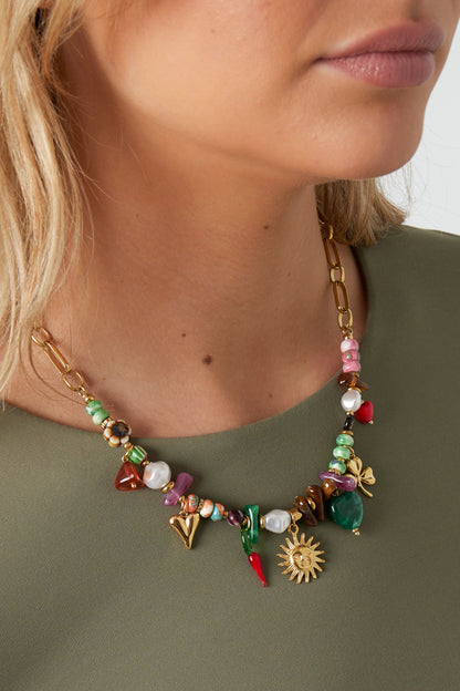 Bead necklace met hart- en zonaccent – speelse kralenketting met hartjes en zonnetjes, gecombineerd met een groene top