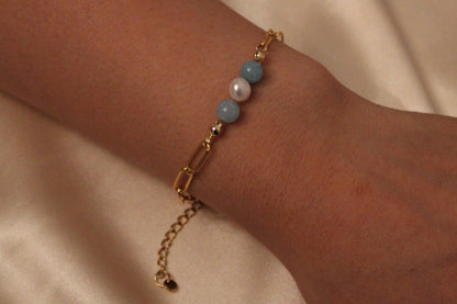 Damespols met stijlvolle armband van aquamarijn en witte parels in goudkleurige afwerking