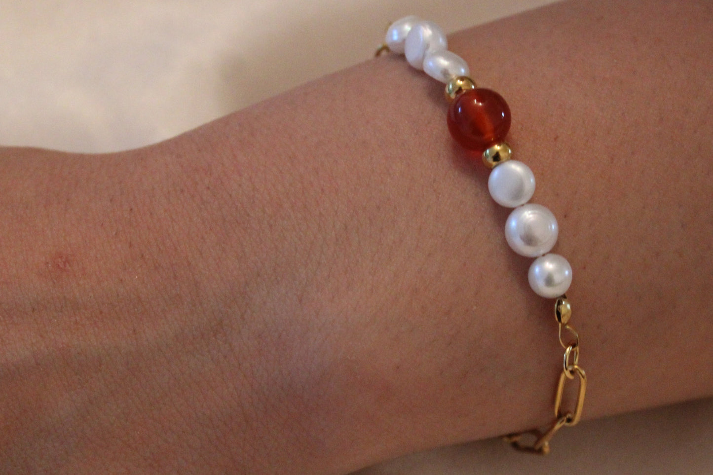 Damespols met elegante armband van goudkleurig stainless steel, parels en carneool