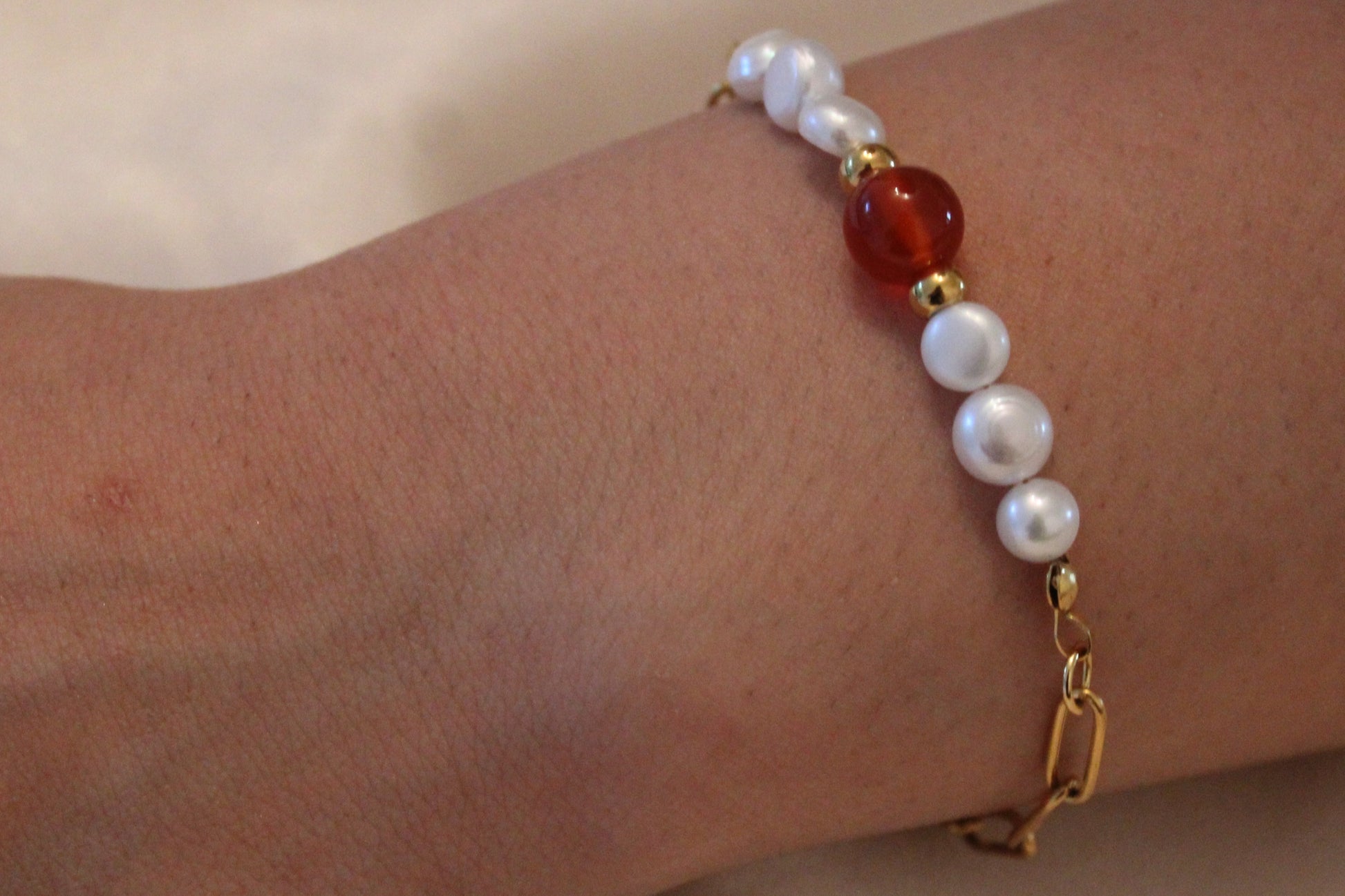Damespols met elegante armband van goudkleurig stainless steel, parels en carneool