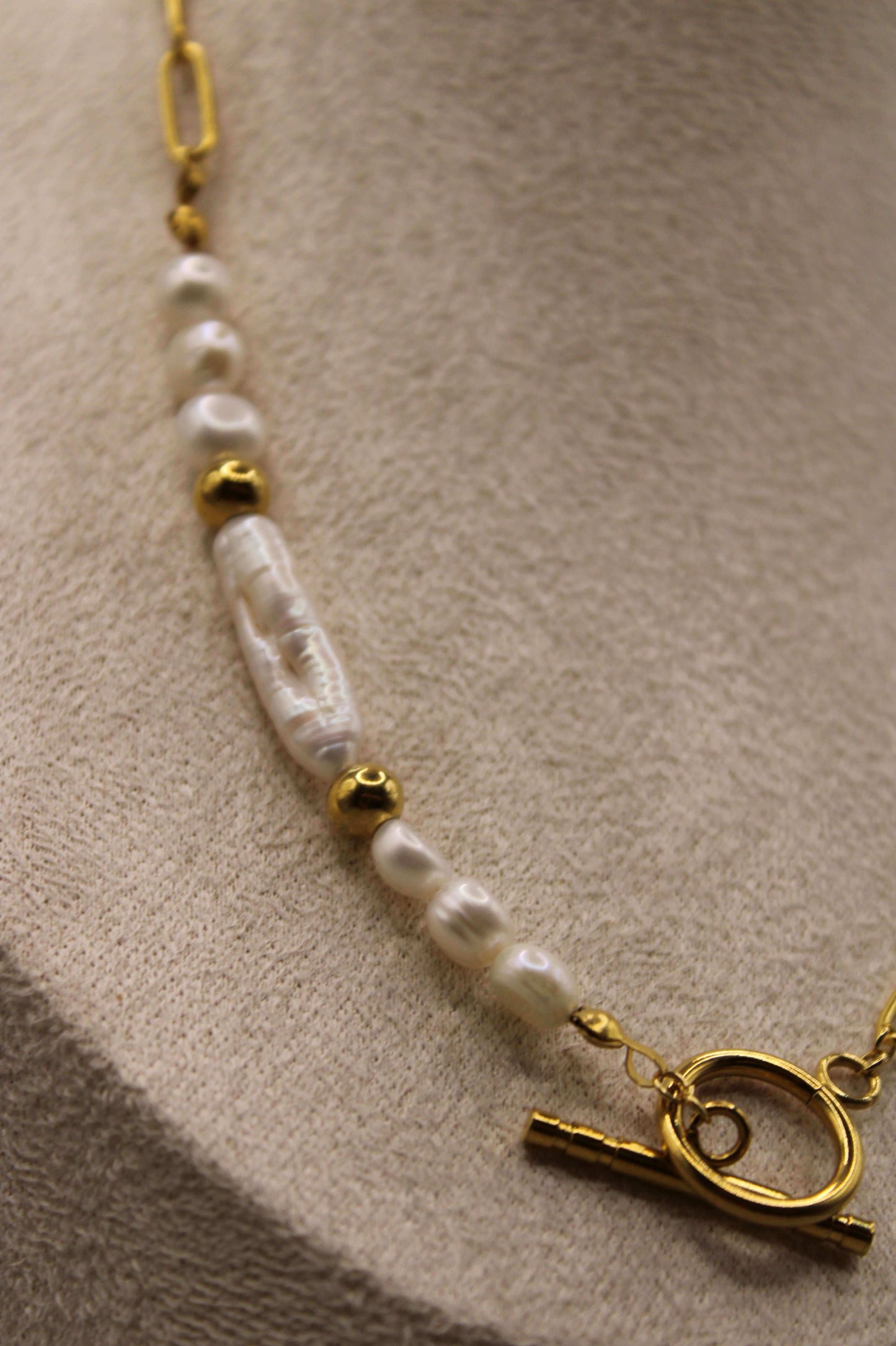 Elegant ontworpen ketting met zoetwaterparels, stainless steel goudkleurige kralen en een stijlvolle ronde sluiting