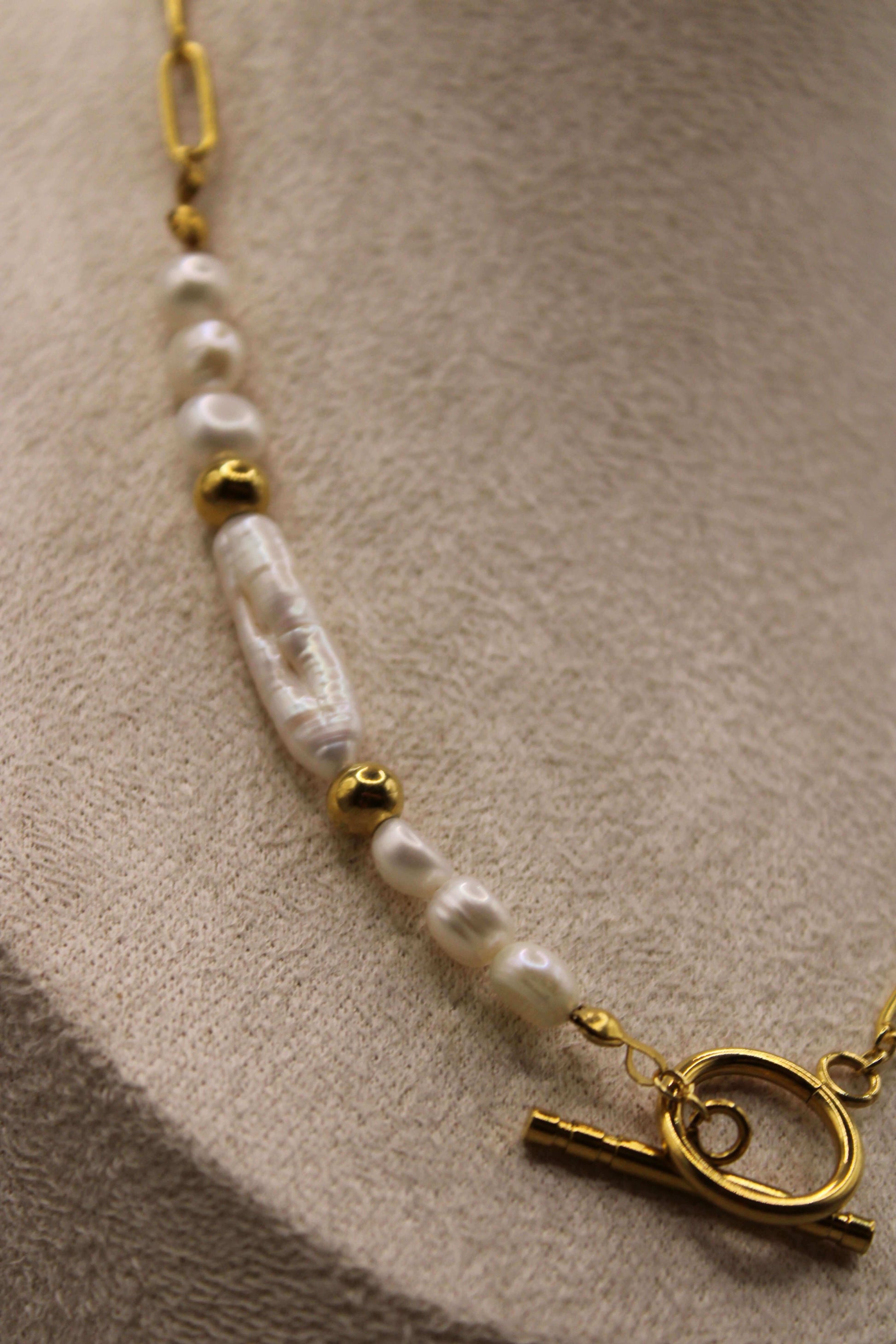 Elegant ontworpen ketting met zoetwaterparels, stainless steel goudkleurige kralen en een stijlvolle ronde sluiting