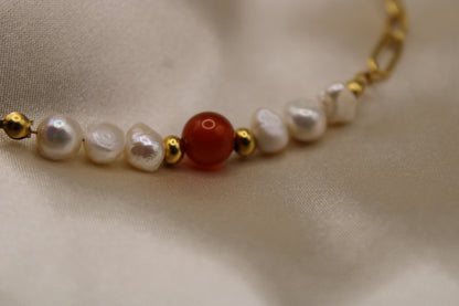 Armband van carneool edelsteen en parels, met goudkleurig stainless steel als materiaal.
