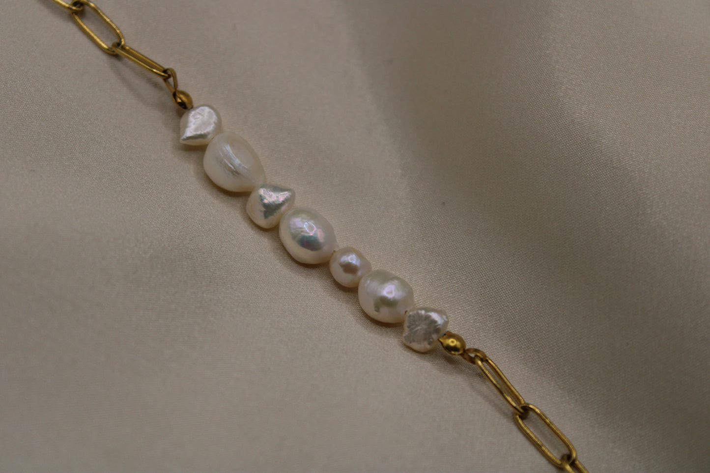 Handgemaakte armband met hoogwaardige zoetwaterparels en goudkleurige stainless steel details.