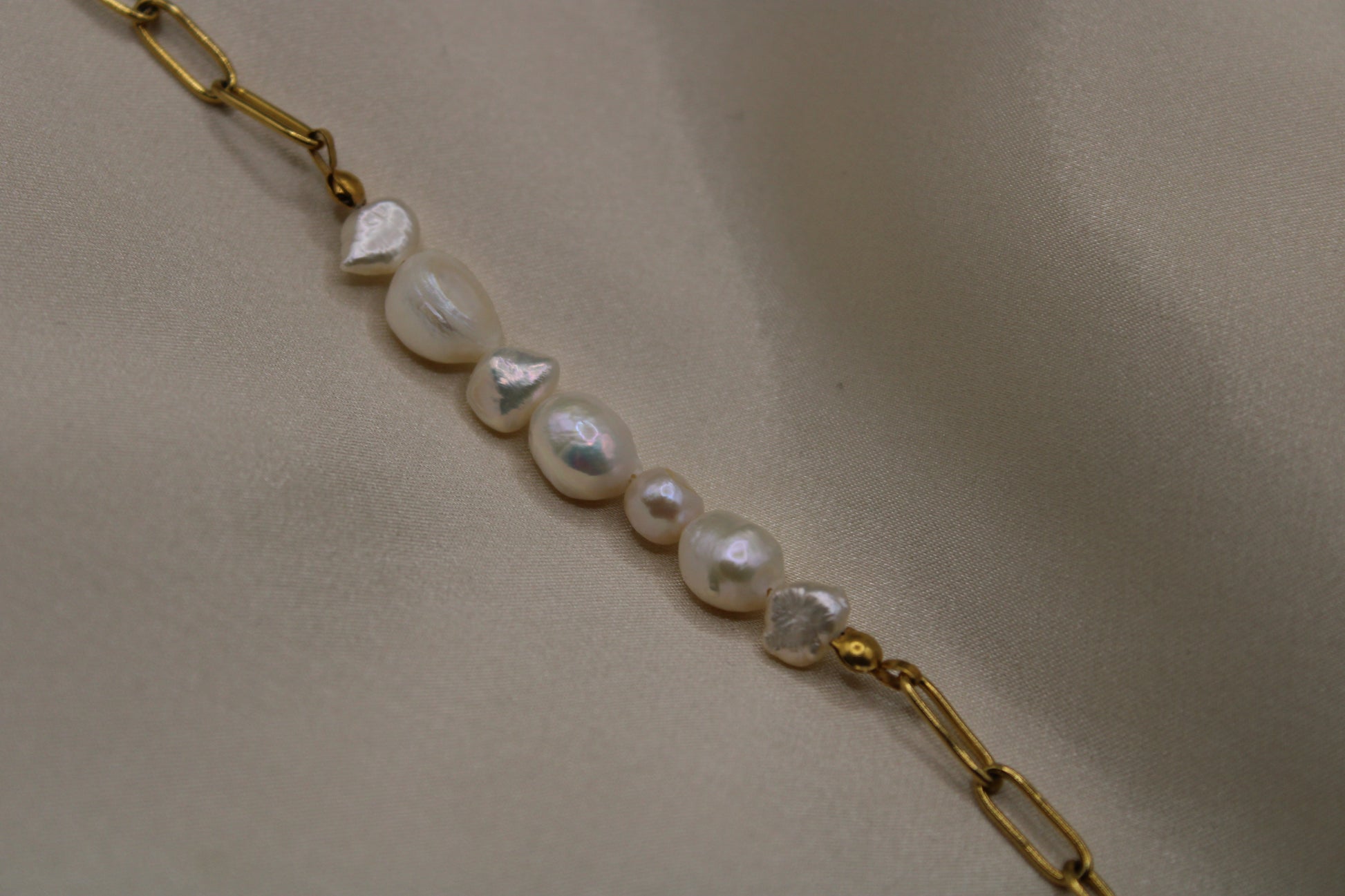Handgemaakte armband met hoogwaardige zoetwaterparels en goudkleurige stainless steel details.