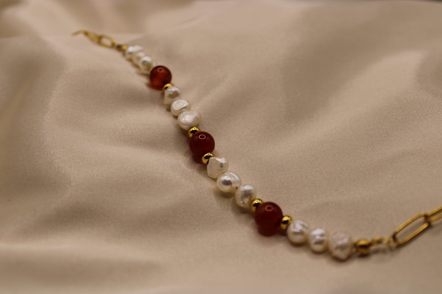 Prachtige zoetwaterparel ketting met carneool edelstenen, gemaakt van goudkleurig stainless steel.
