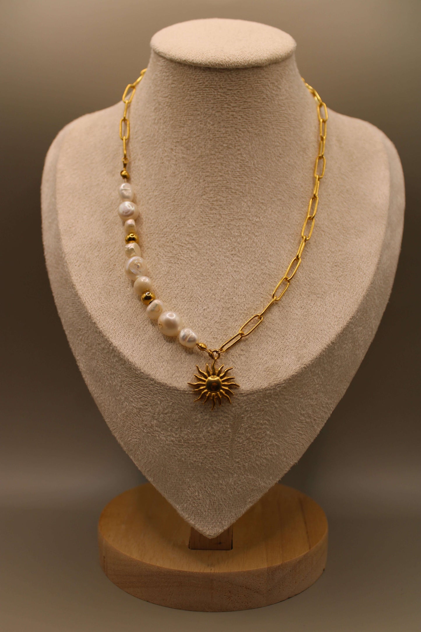 Ketting van goudkleurig stainless steel met zonvormige hanger, zoetwaterparels en kralen.