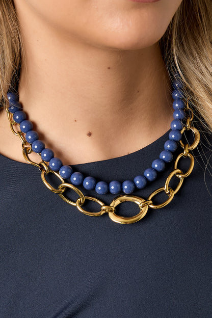  Model draagt korte goudkleurige RVS schakelketting rond het sleutelbeen