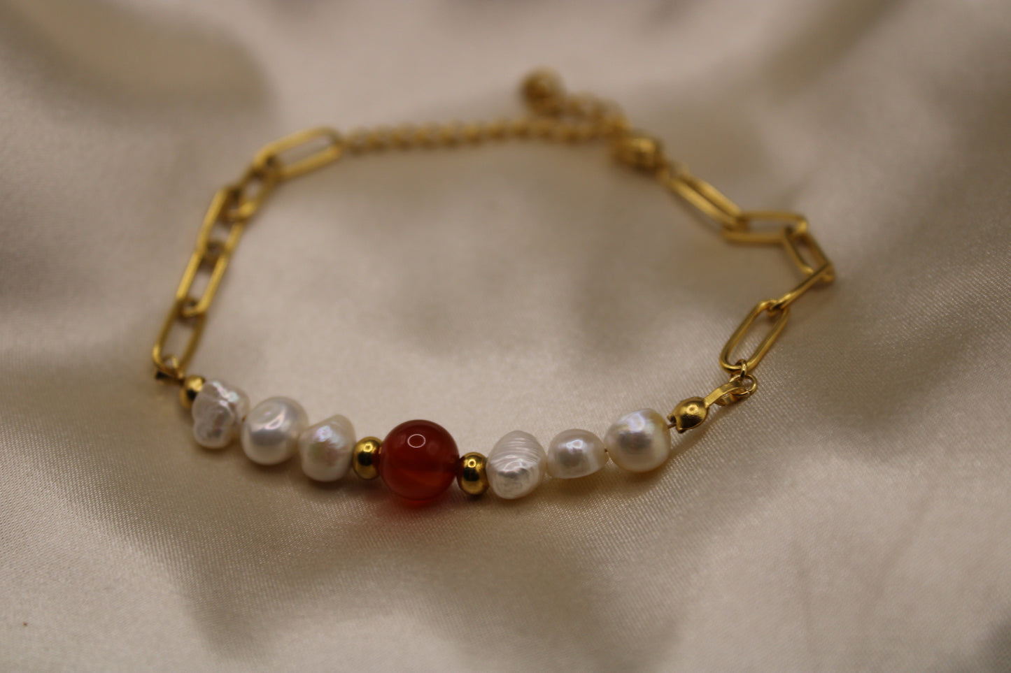 Armband met parels en carneool edelsteen, vervaardigd uit hoogwaardig goudkleurig stainless steel.
