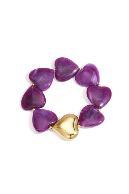 Donkerpaarse retro armband met acryl hartkralen en goudkleurige kralen in close-up