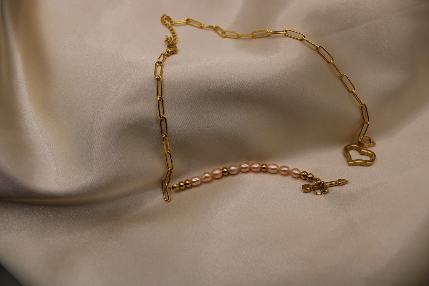 Ketting met roze zoetwaterparels, gouden kralen en hartvormige sluiting.