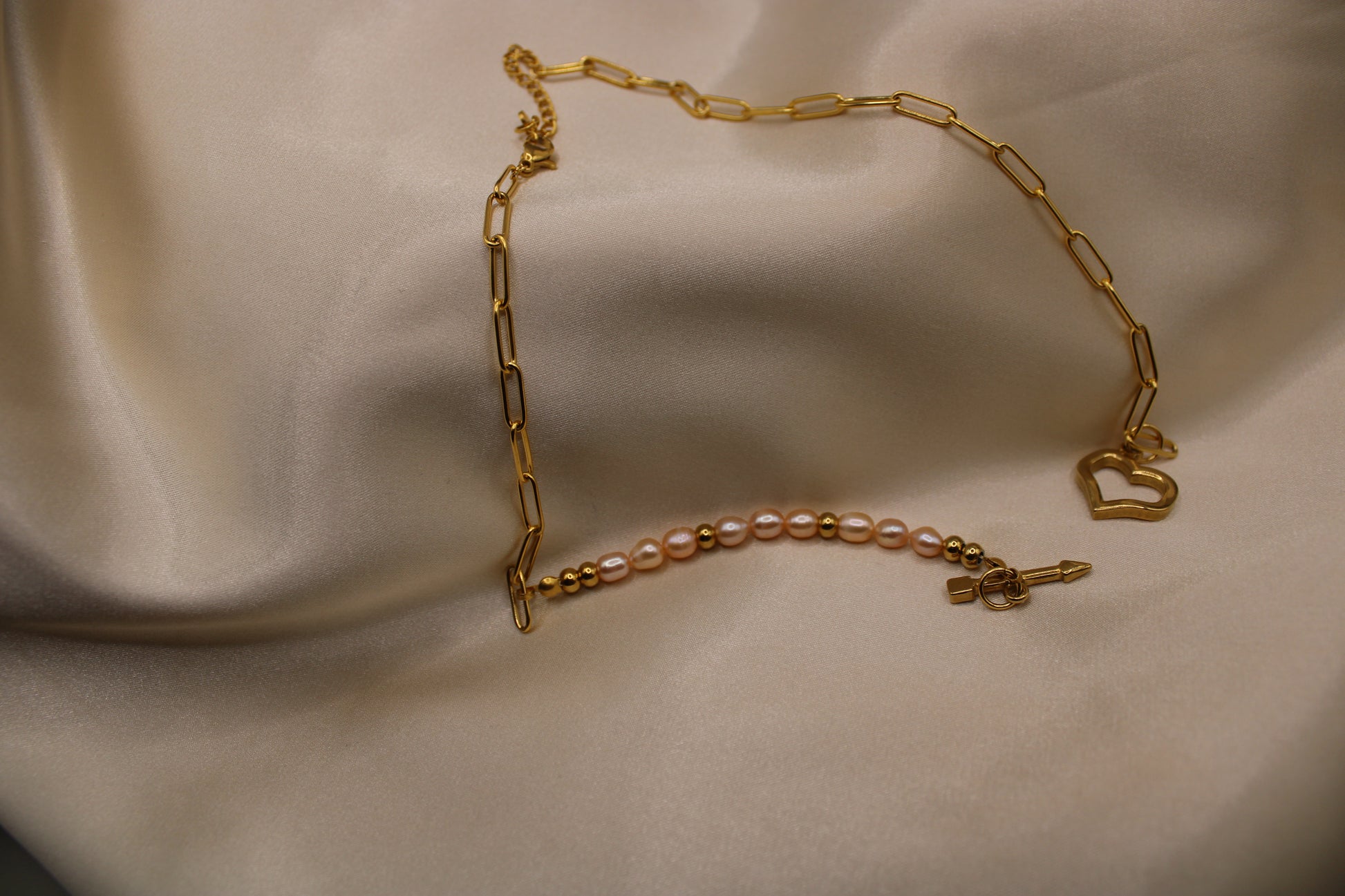 Ketting met roze zoetwaterparels, gouden kralen en hartvormige sluiting.