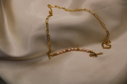 Ketting met roze zoetwaterparels, gouden kralen en hartvormige sluiting.